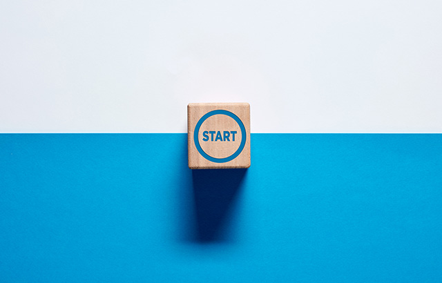 The word Start on wooden cube push button on blue and white background. To make a new start in life, business, education or career concept. Start button.