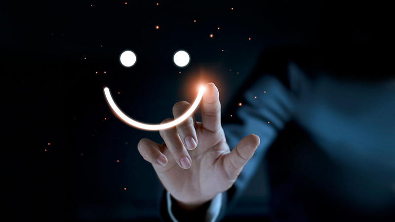 Finger of businessman touching and drawing face emoticon smile on dark background, service mind, service rating. Satisfaction and customer service concept.