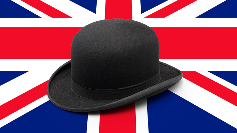 A stylish black bowler hat on UK flag textured wooden table