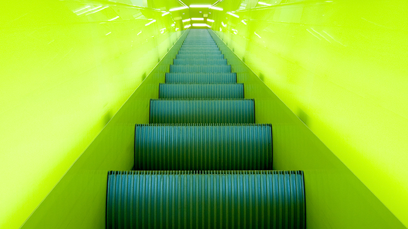 Neon green illuminated futuristic escalator.