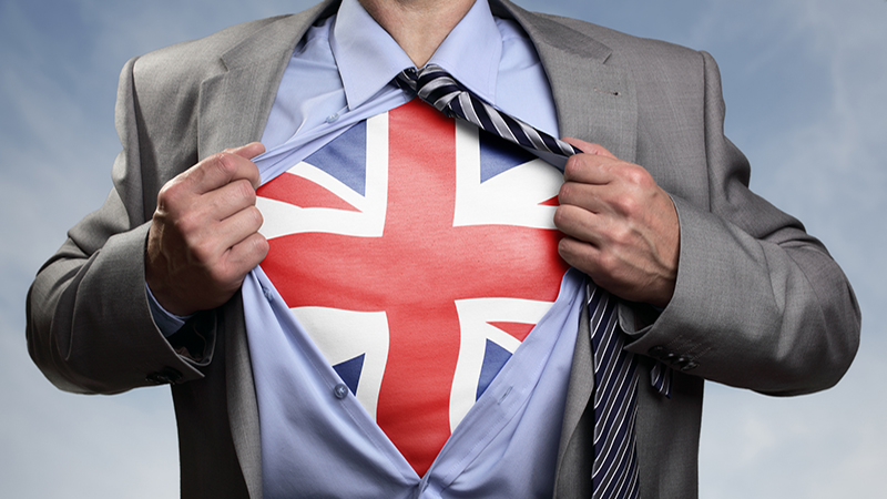 Businessman in classic superman pose tearing his shirt open to reveal t shirt with the British union jack flag concept for european referendum, patriotism, freedom and national pride