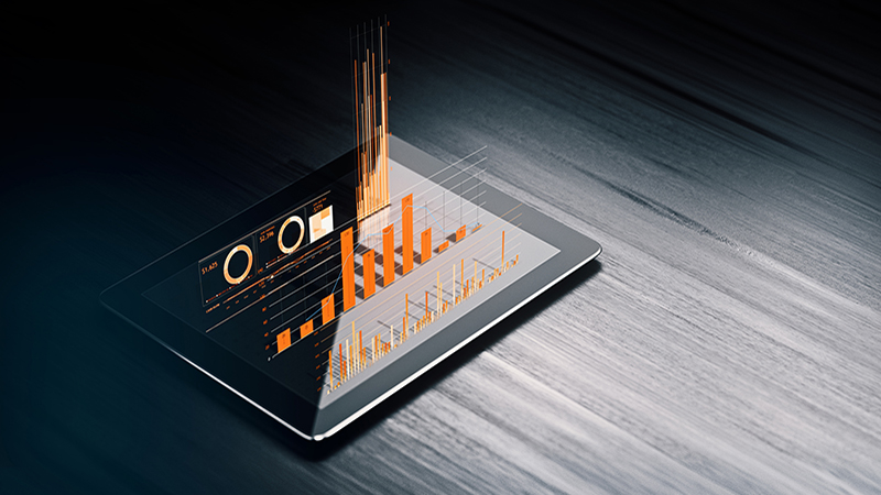 Financial data analysis graph on a digital tablet over black wood surface. Selective focus. Horizontal composition with copy space.