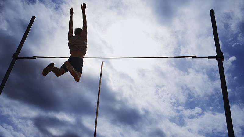 Pole vaulter in mid-air representing outstanding performance