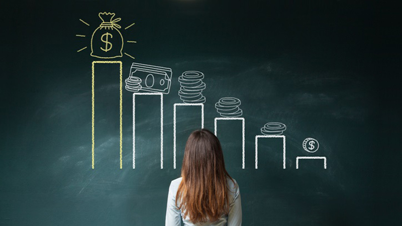 Business woman standing in front of a blackboard with a financial chart