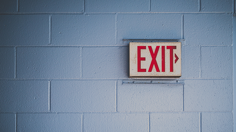 Outdoor exit sign on a brick wall