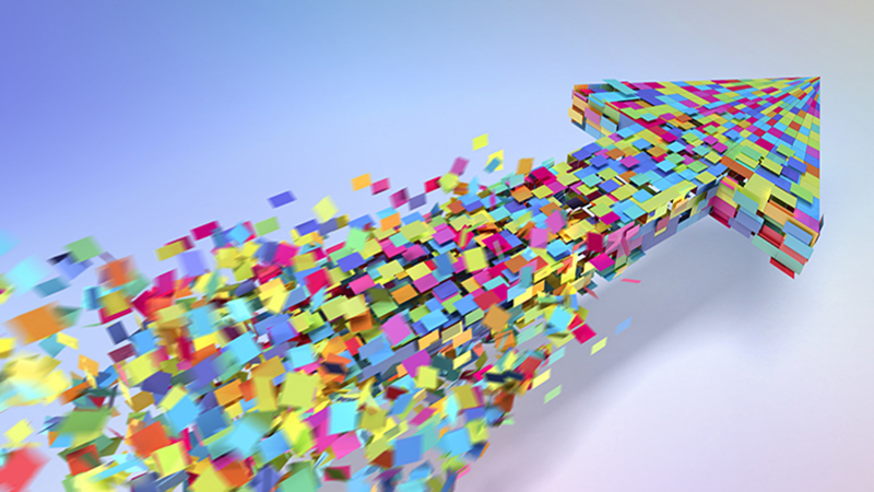 Lots of multi-coloured square coming together to form a three dimensional arrow. The squares are forming in the wake of the arrow head and are moving with motion blur. Arrow is on a light background with pastel colours around the outer edges.