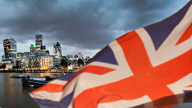 union jack flag over London financial district with iconic skyscrapers, UK prepares for elections after Brexit