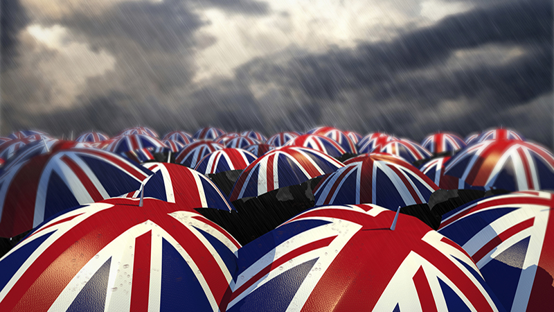 A drizzly, British and rainy day with an array of British flag umbrellas in crowd formation