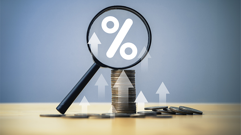 Coins money stacking with up arrow and percentage symbol inside magnifier glass for financial banking increase interest rate or mortgage investment dividend from business growth concept.