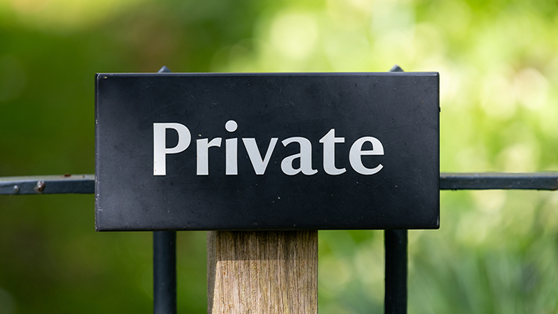 Close up of a wooden sign that says private