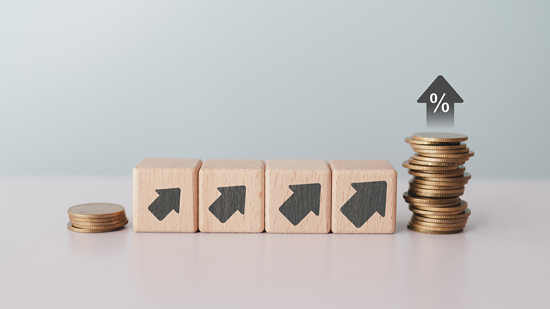 Stack of coins and up arrow on wooden cube blocks with copy space. Business financial, successful investment, money saving increase, retirement planning, business growing, inflation concept