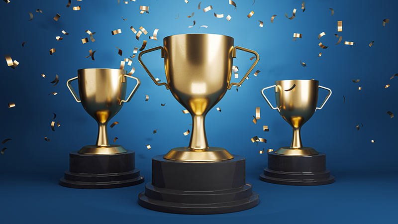 Three golden trophies with falling confetti on a blue background, symbolizing achievement and victory. 3D Rendering