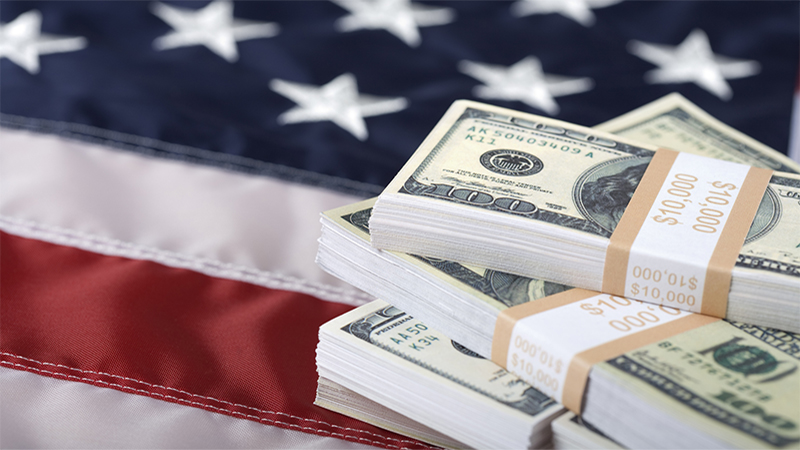 Macro shot of bundles of new $100 bills on US flag. Selective focus on the money.